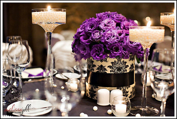 Purple and black centerpieces with tall candle holders